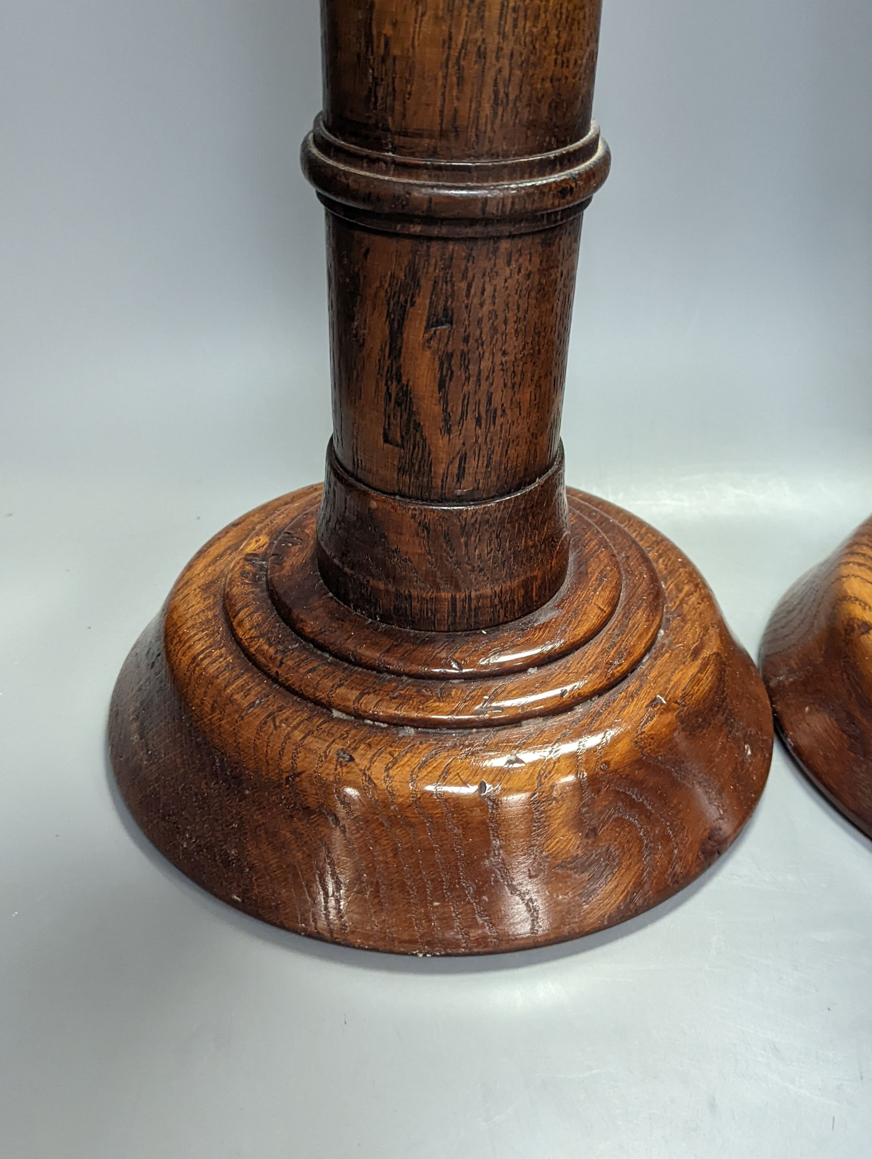 A pair of Pugin inspired Gothic style oak pricket candlesticks, height 56cm